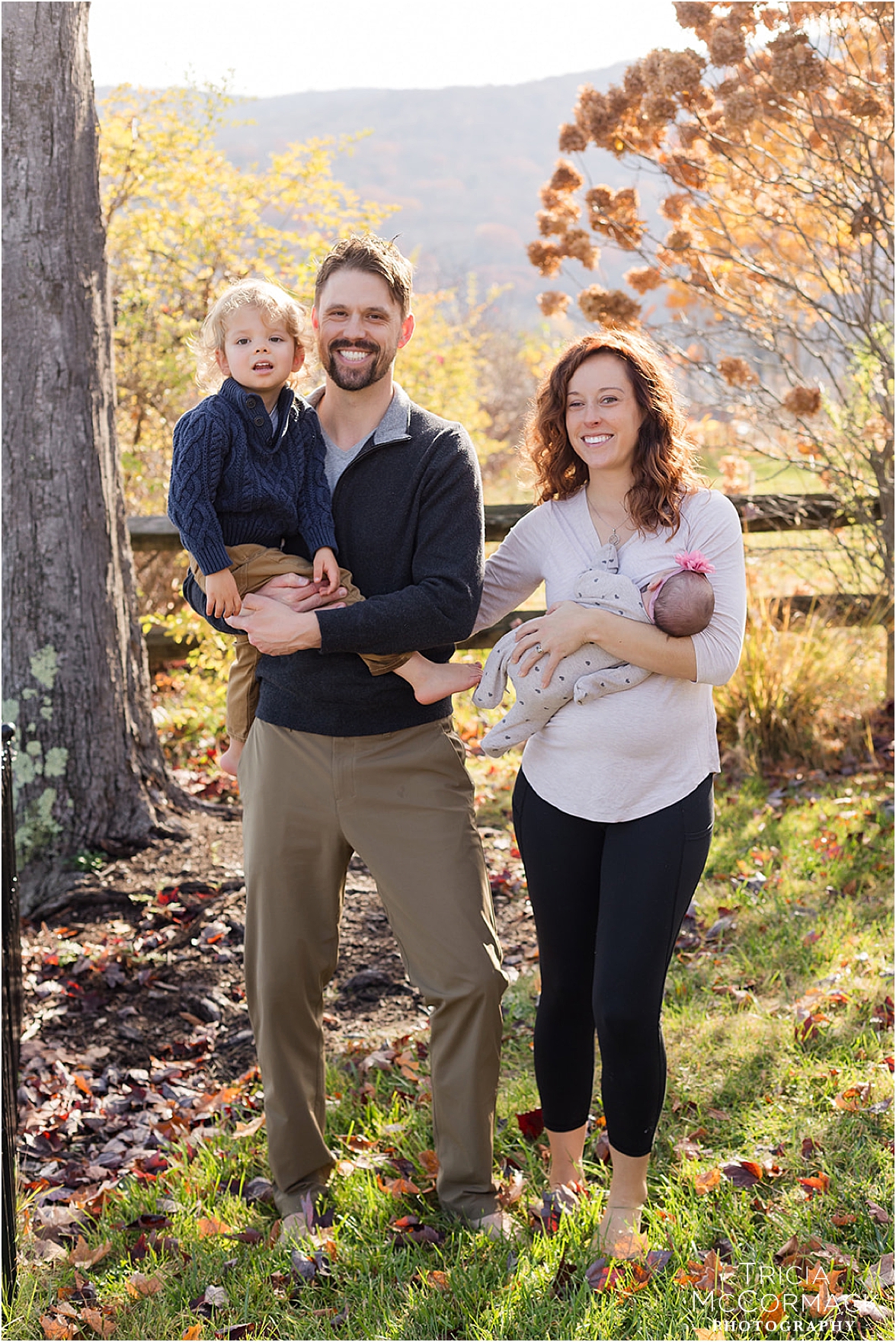 Lifestyle newborn photography featuring mother, father, and children in natural light by Tricia McCormack.